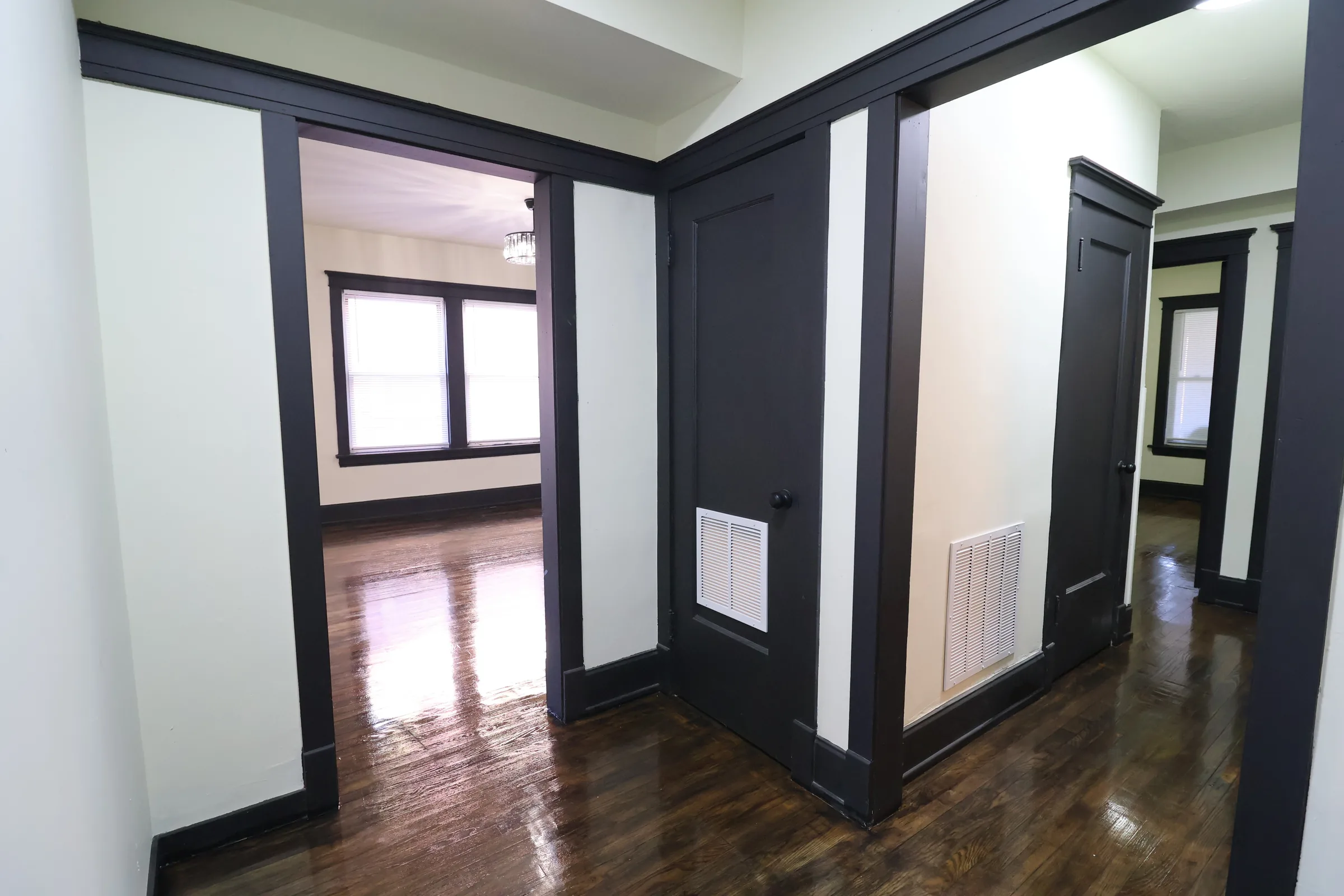 Finished hallway with dark trim and doors
