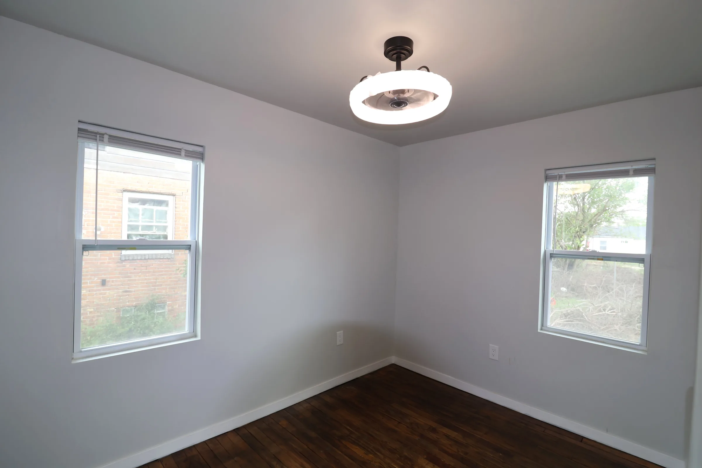 Finished bedroom with hardwood floors and windows